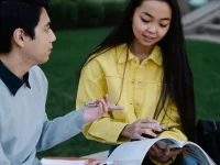 Dua mahasiswa belajar bersama di lingkungan kampus