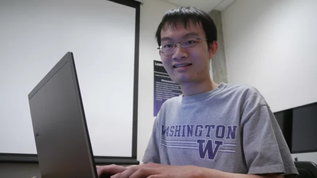 Seorang mahasiswa belajar dengan membuka laptop.