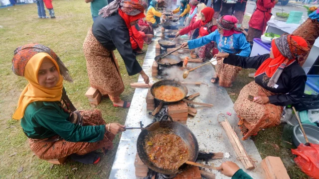 Tradisi marandang, ibu-ibu memasak rendang daging dalam kuali di Sumatera Barat