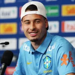 Gabriel Martinelli mengenakan kaus tim nasional Brasil dalam konferensi pers