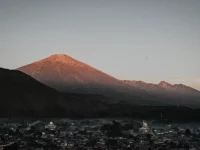 Gunung Rinjani diterpa cahaya matahari terbit di atas permukiman di Nusa Tenggara Barat