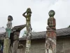 Tiga patung sapundu kayu berdiri di depan rumah Betang Toyoi, Kalimantan
