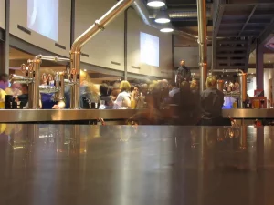 Meja bar logam dengan keran bir di bar Zero Degrees, Bristol, Inggris