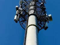 Ilustrasi menara telekomunikasi dengan antena di bawah langit biru