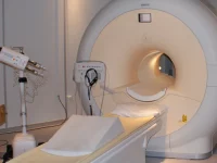 Mesin pemindai MRI dengan meja pasien di ruang pemeriksaan rumah sakit