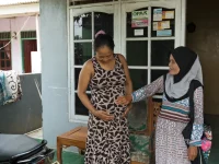 Seorang motivator kesehatan mendampingi ibu hamil membahas kepesertaan BPJS dan fasilitas kesehatan di Indonesia.