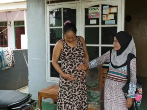 Seorang motivator kesehatan mendampingi ibu hamil membahas kepesertaan BPJS dan fasilitas kesehatan di Indonesia.