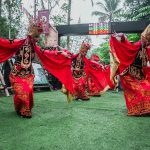 Penari Gandrung Banyuwangi berkostum merah menari di panggung terbuka.