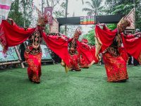 Penari Gandrung Banyuwangi berkostum merah menari di panggung terbuka.