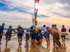Sekelompok nelayan mendorong perahu bercadik ke laut di Pantai Kedonganan, Bali