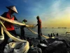 Nelayan menarik jaring ikan bersama-sama di pesisir Indonesia