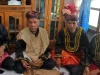 Empat pemangku adat Kerinci berbaju hitam bersulam emas dan berkuluk duduk bersila di rumah adat
