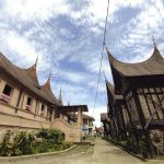 Rumah gadang beratap gonjong berdampingan dengan rangkiang di Sumatera Barat.