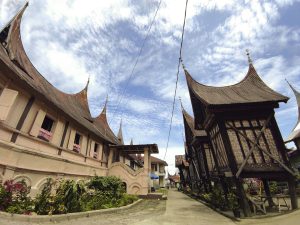 Rumah gadang beratap gonjong berdampingan dengan rangkiang di Sumatera Barat.