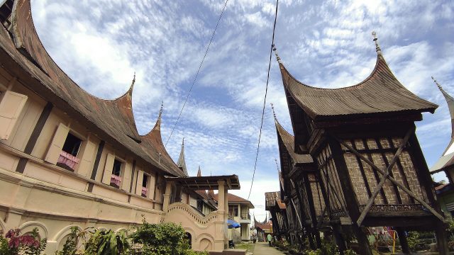 Rumah gadang beratap gonjong berdampingan dengan rangkiang di Sumatera Barat.