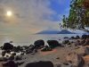 Pantai berbatu di Tidore dengan siluet Gunung Gamalama di Pulau Ternate di kejauhan.