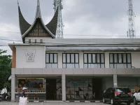 Bangunan rumah makan beratap gonjong dengan papan nama di Kota Padang