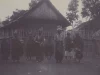 Pasangan pengantin berdiri bersama sejumlah orang di depan rumah beratap tinggi di Laut Tawar