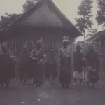 Pasangan pengantin berdiri bersama sejumlah orang di depan rumah beratap tinggi di Laut Tawar