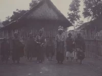 Pasangan pengantin berdiri bersama sejumlah orang di depan rumah beratap tinggi di Laut Tawar