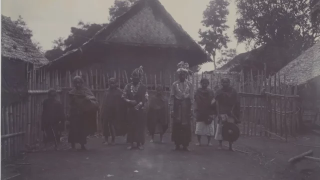 Pasangan pengantin berdiri bersama sejumlah orang di depan rumah beratap tinggi di Laut Tawar