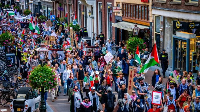 Warga membawa bendera Palestina dalam pawai di jalanan Leiden, Belanda