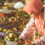 Seorang pedagang buah berjilbab merapikan dagangan di pasar terapung Banjarmasin