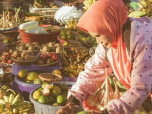 Seorang pedagang buah berjilbab merapikan dagangan di pasar terapung Banjarmasin