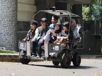 Mahasiswa menumpang kendaraan hybrid Pedaltrax buatan ITB di lingkungan kampus