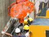 Ilustrasi pekerja berhelm memandu alat berat di lokasi proyek
