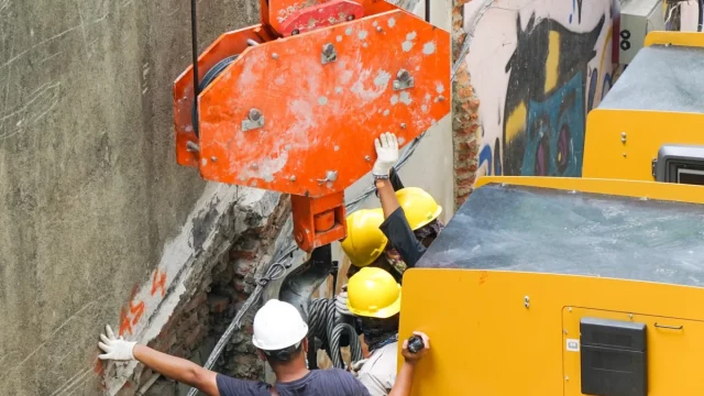 Ilustrasi pekerja berhelm memandu alat berat di lokasi proyek