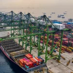 Kapal kargo bersandar di bawah deretan derek terminal peti kemas Jakarta Utara