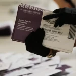 Petugas Dinas Pemilu California menyortir surat suara yang dikirim lewat pos di San Francisco.