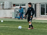Seorang pemain sepak bola berlatih mengolah bola di lapangan berumput