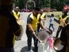 Beberapa laki-laki berseragam kuning hitam memukul kompang dan sebuah bass drum di jalan