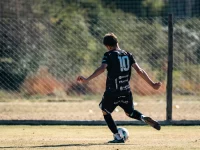 Pemain sepak bola menendang bola dalam pertandingan