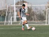 Pemain muda menggiring bola di lapangan