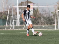 Pemain muda menggiring bola di lapangan