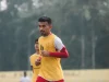 Pemain sepak bola berompi kuning berlari dalam sesi latihan di lapangan