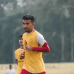Pemain sepak bola berompi kuning berlari dalam sesi latihan di lapangan