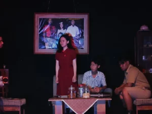 Lima aktor dalam satu adegan pementasan teater di panggung berlatar ruang tamu yang gelap