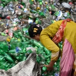 Perempuan memilah botol plastik bekas untuk didaur ulang