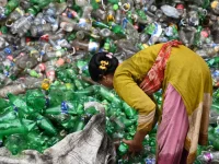 Perempuan memilah botol plastik bekas untuk didaur ulang