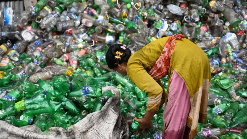 Perempuan memilah botol plastik bekas untuk didaur ulang