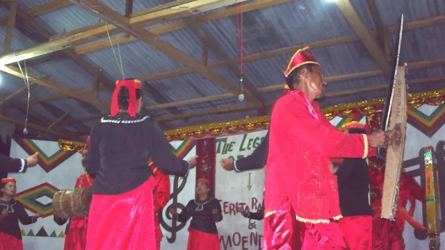 Penari adat Pamona berbusana merah membawakan tarian di atas panggung festival