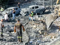 Ekskavator menggali saat tim penyelamat mencari korban di Kfar Reman, Lebanon selatan