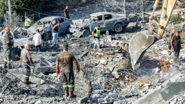 Ekskavator menggali saat tim penyelamat mencari korban di Kfar Reman, Lebanon selatan
