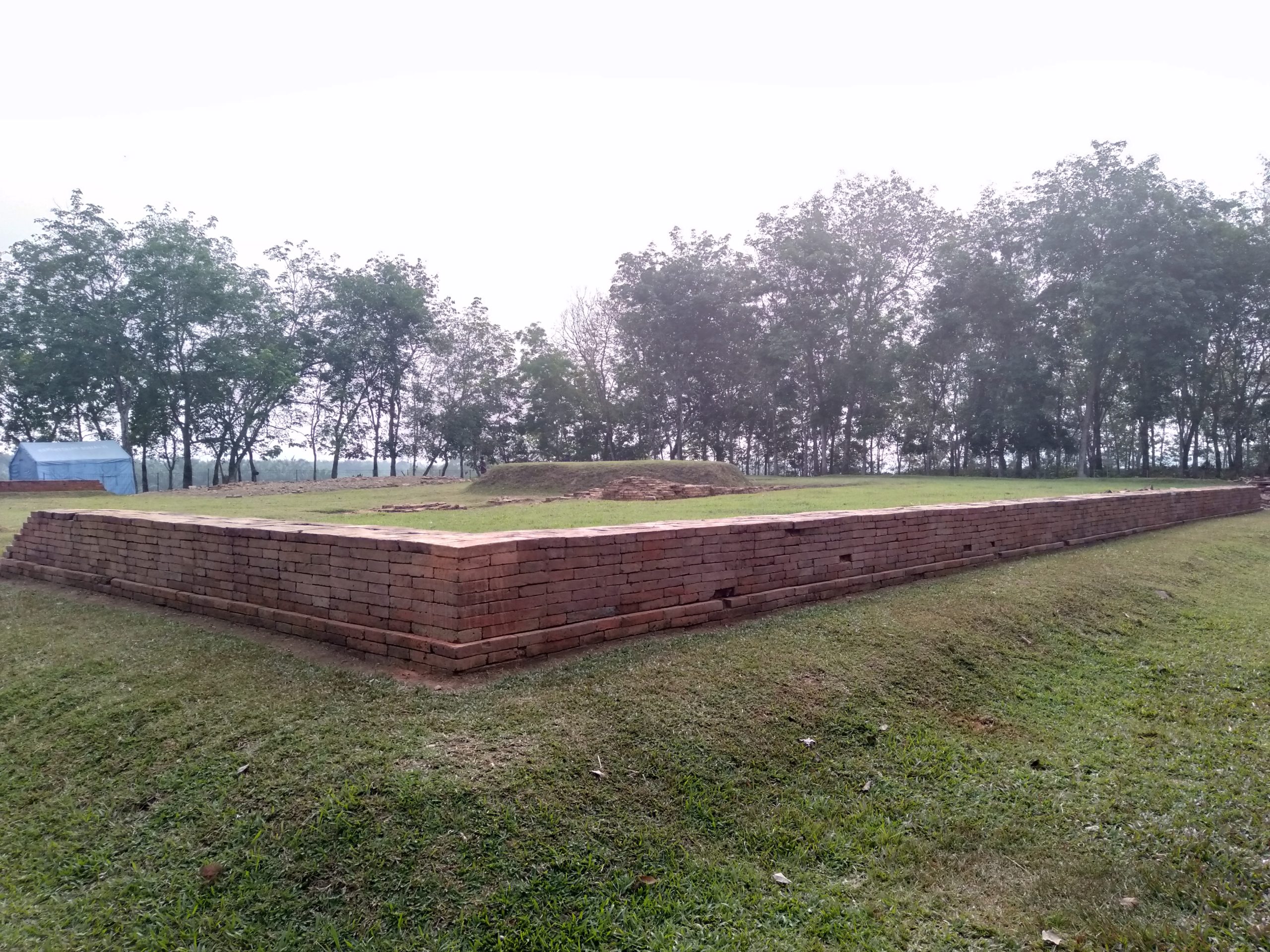 Struktur bata Candi Pulau Sawah di Dharmasraya yang tersisa di tengah lapangan berumput.