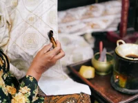 Ilustrasi perajin membatik kain dengan canting di Yogyakarta