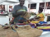 Perajin Papua merajut sekaligus menjual noken, tas rajut tradisional Papua.